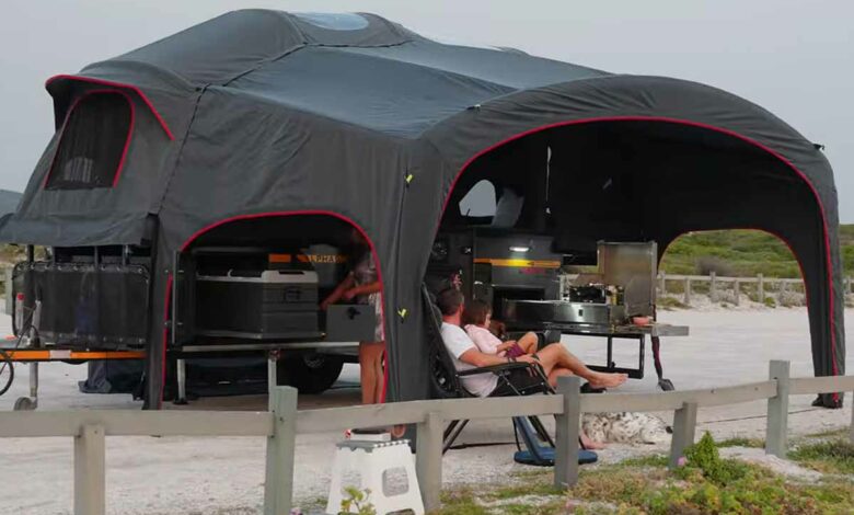 Une caravane luxueuse dotée d'une tente gonflable.