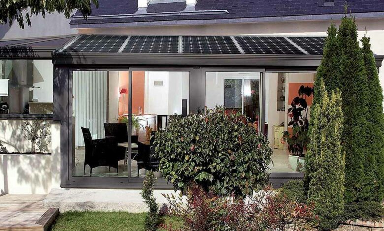 Une véranda de construction française avec des panneaux photovoltaïques sur sa toiture.