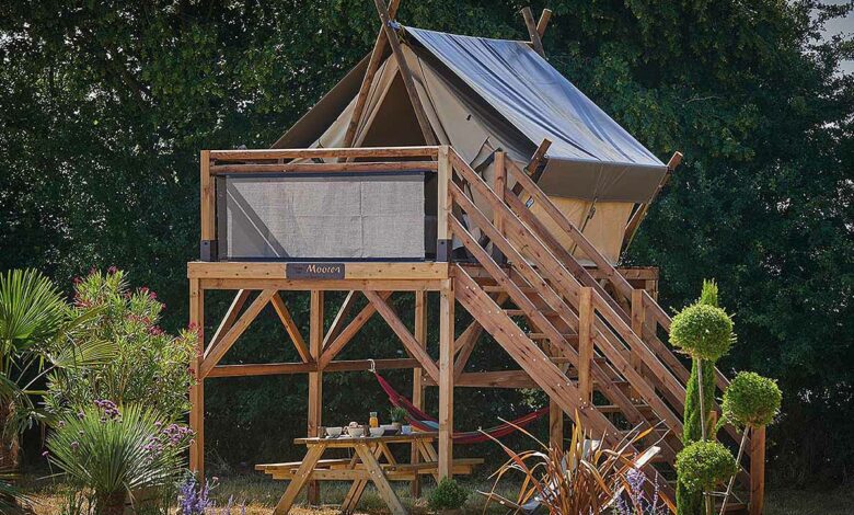 Une tente de camping montée sur une terrasse en bois.