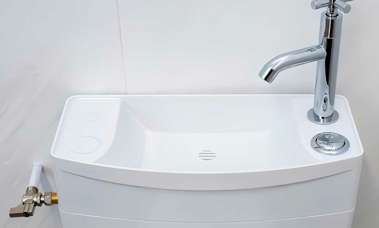Un lavabo au-dessus du réservoir des toilettes.