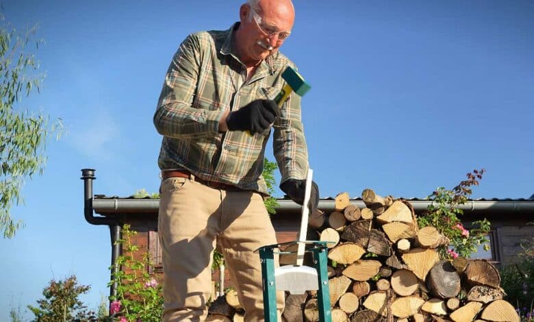 Un homme utilise un refendeur de buche.