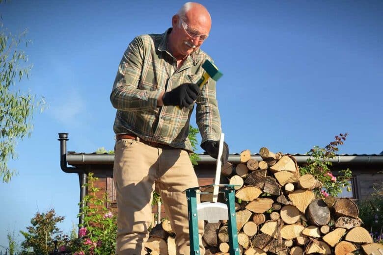 Un homme utilise un refendeur de buche.