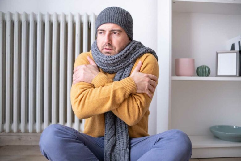 Un homme qui a froid dans un appartement.