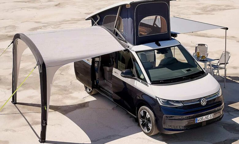 Un van Volkswagen avec auvent et tente de toit déployés.