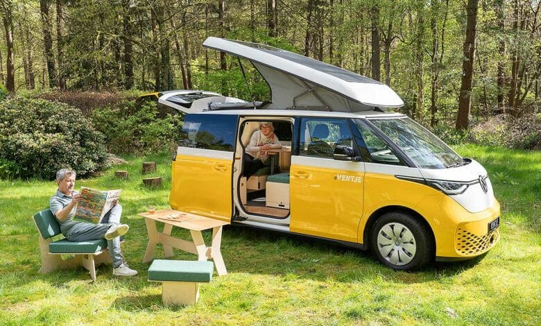 Un couple se détend dans la nature à côté de leur van aménagé.