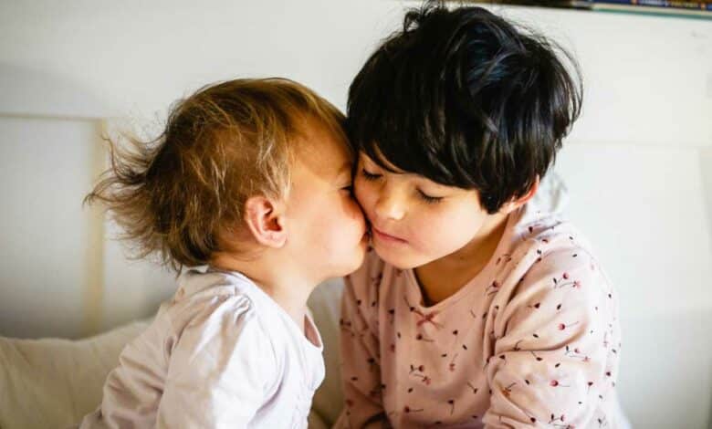 Deux enfants qui s'embrassent sur la joue.