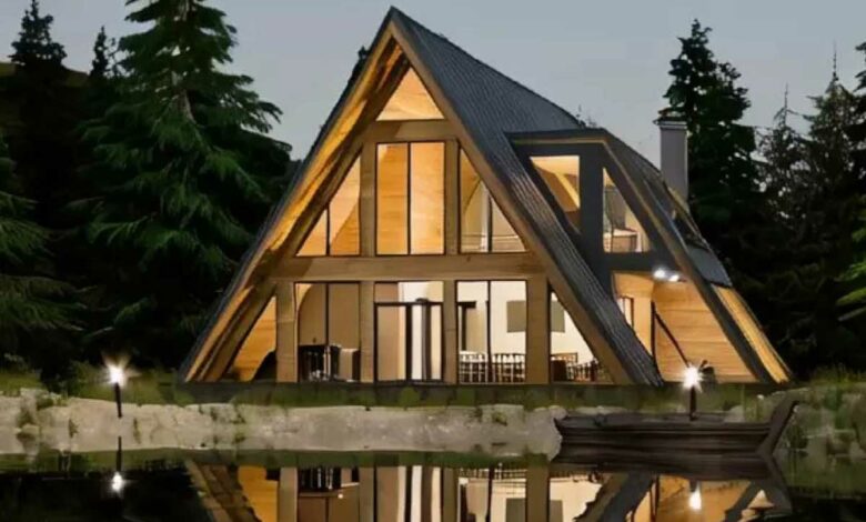 Une maison en A et son reflet face à un plan d'eau.