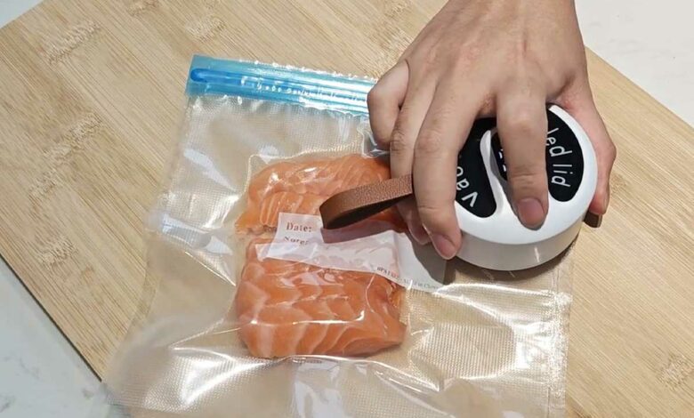 Un Sealvo met sous vide un morceau de saumon.