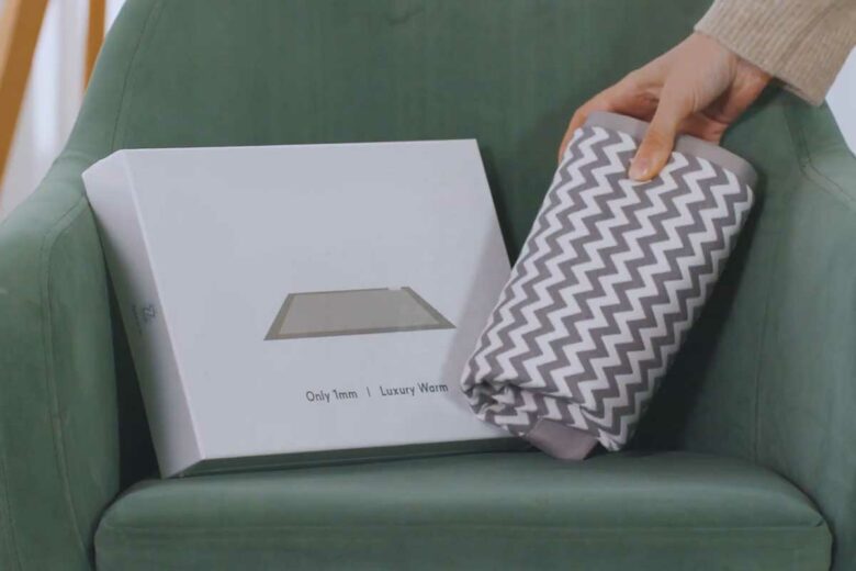 Un coussin chauffant posé sur un canapé.