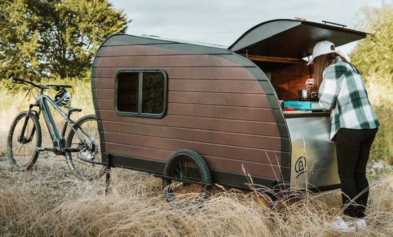 Une mini-caravane tractée par un vélo.