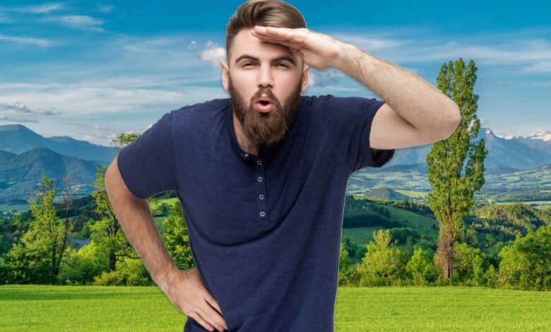 Un homme regarde au loin, devant un paysage.