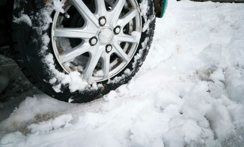 Une voiture roule dans la neige.
