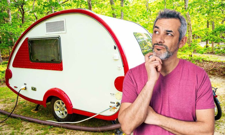 Un homme sceptique devant une mini caravane.