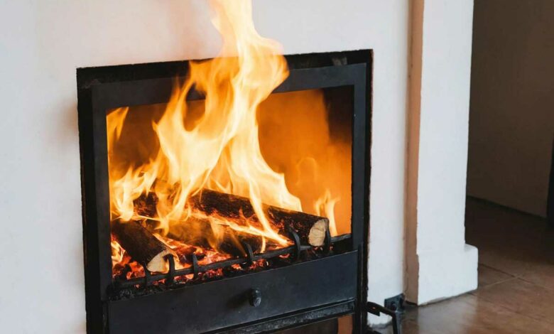 Des flammes sortent du foyer de la cheminée.