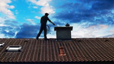 Un homme sur le toit d'une maison pour le ramonage.