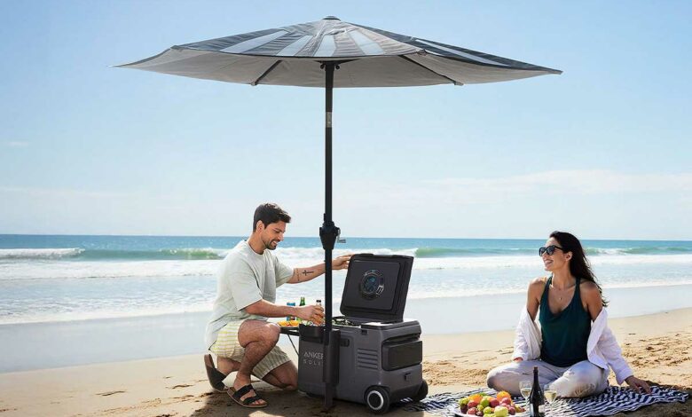 Un couple sur la plage sous un parasol avec une glacière.