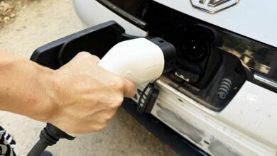 Une personne va recharger son véhicule électrique.