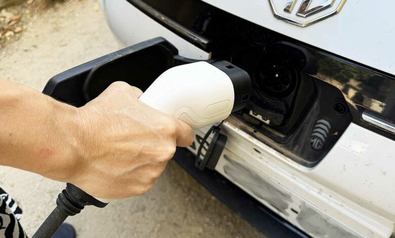Une personne va recharger son véhicule électrique.