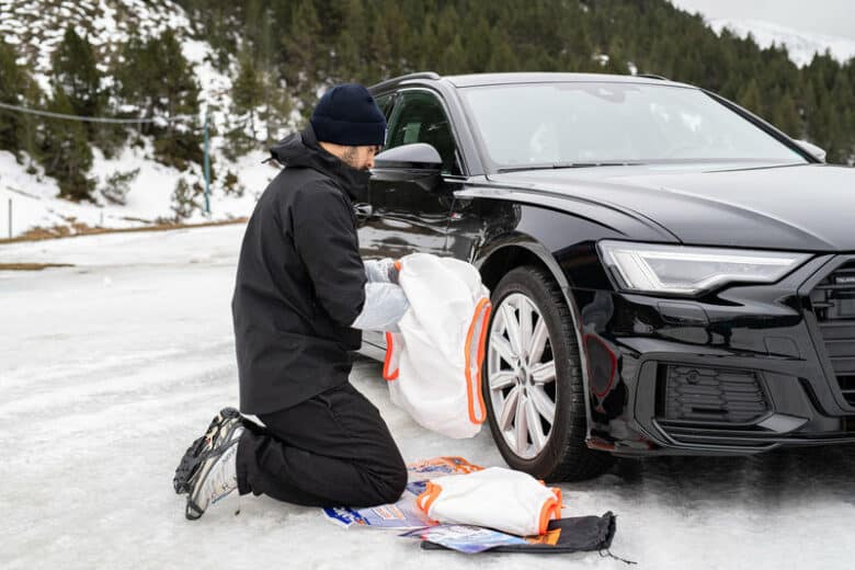 Un homme installe des chaussettes à neige.