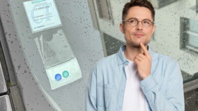 Un homme pensif et un pare-brise sans carte verte d'assurance.