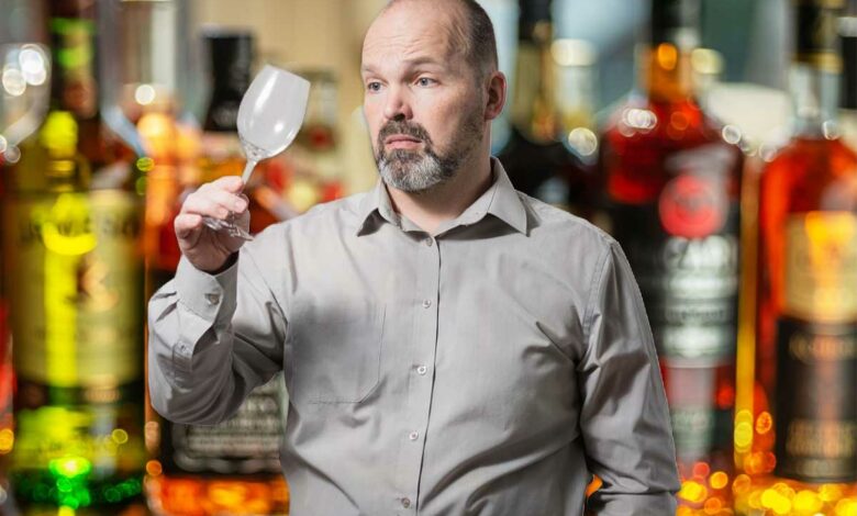 Un homme regarde son verre vide.