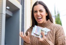 Une femme enrage avec des billets dans les mains.