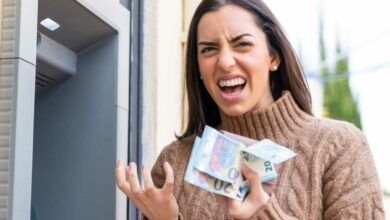 Une femme enrage avec des billets dans les mains.