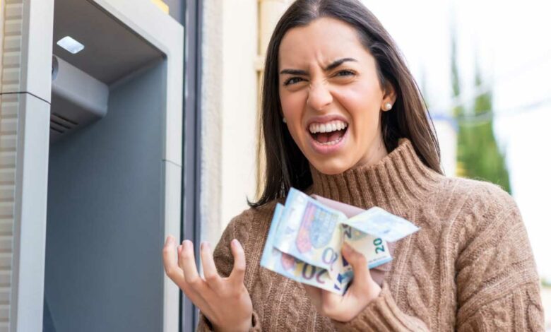 Une femme enrage avec des billets dans les mains.