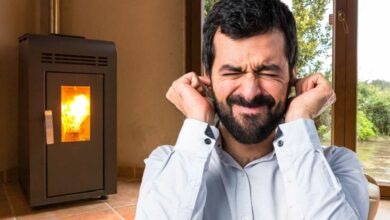Un homme se bouche les oreilles devant un poêle.
