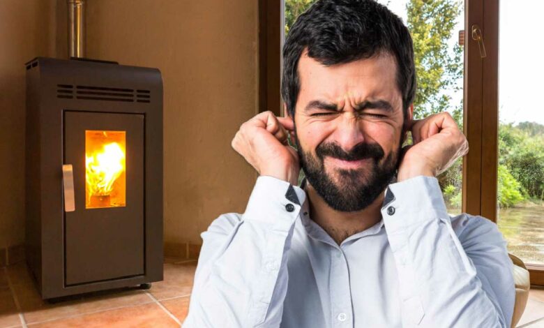 Un homme se bouche les oreilles devant un poêle.