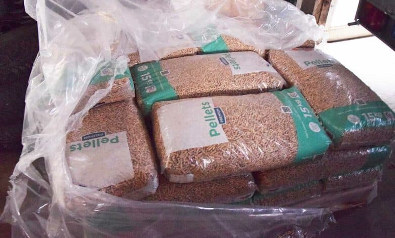 Des pellets en sacs stockés dans un abri.