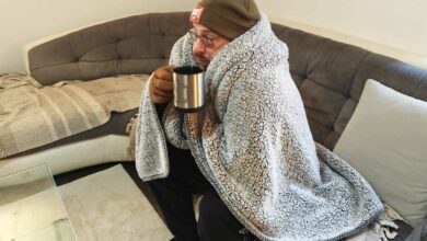 Un homme a froid sur son canapé.