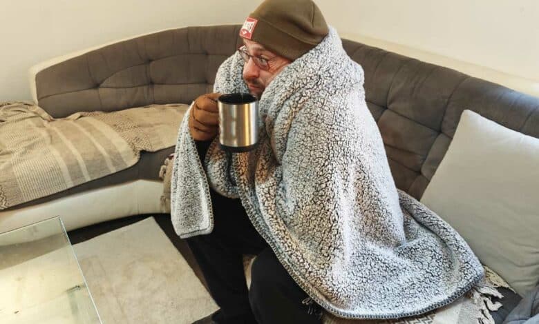 Un homme a froid sur son canapé.