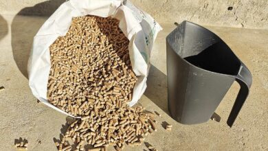 Une pelle à pellets à côté d'un sac de granulés.