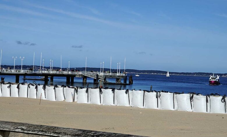 Des sacs de sable en ligne sur une plage.