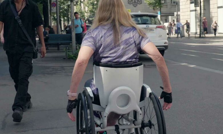 Une personne aux cheveux longs dans un fauteuil roulant.