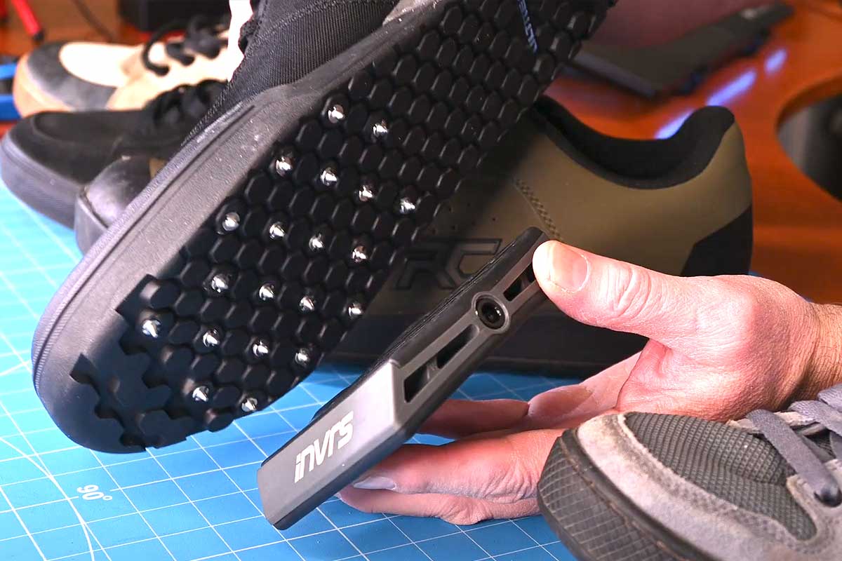 Une chaussure cloutée qui se pose sur la pédale.