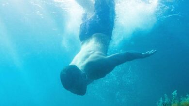 Un homme plonge dans l'eau.