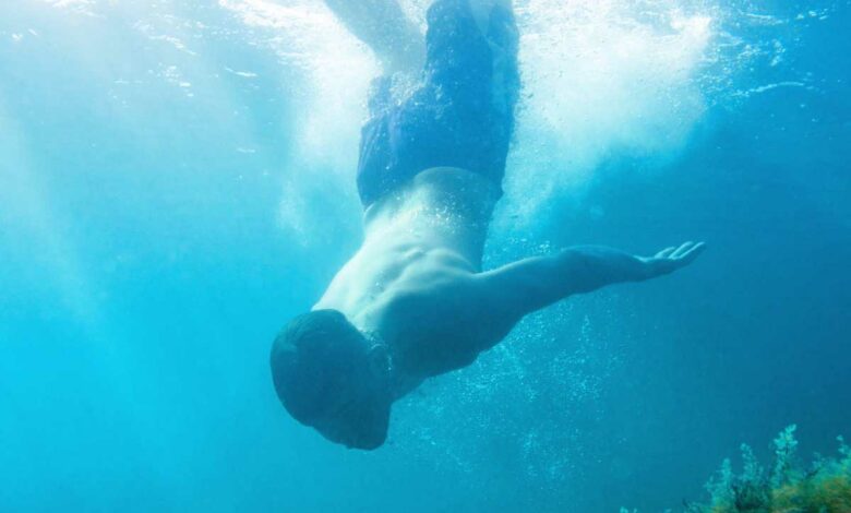 Un homme plonge dans l'eau.