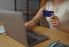 Une femme effectue un achat en ligne sur son ordinateur.