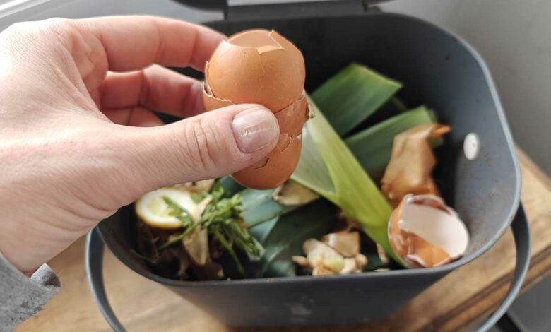 Une personne dépose des déchets alimentaires au compost.