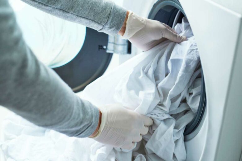 Une personne sort des draps d'un électroménager.