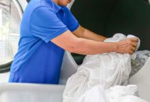 Une femme s'occupe du linge dans une blanchisserie.