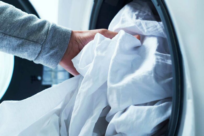Une personne sort des draps d'un électroménager.