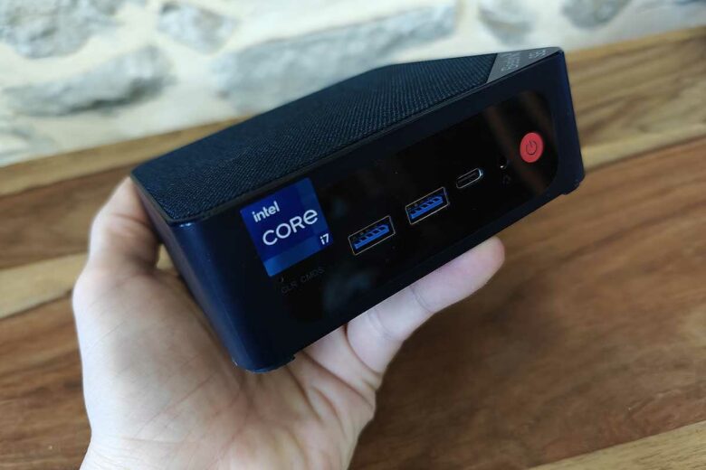 Une personne tient un mini PC en main.