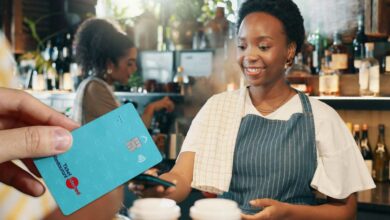 Une personne paie la note avec sa carte ticket resto.