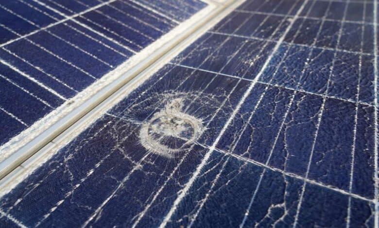 Un panneau solaire brisé avec un impact de grêlon.