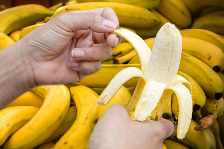Une personne épluche une banane.
