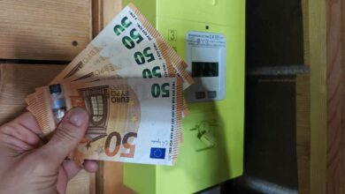 Un compteur Linky et une main tenant des billets.