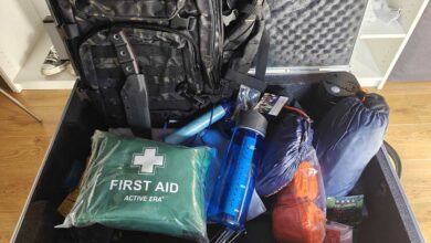Un kit d'urgence avec une trousse de soins, des gourdes filtrantes, un panneau solaire et un couteau de survie.